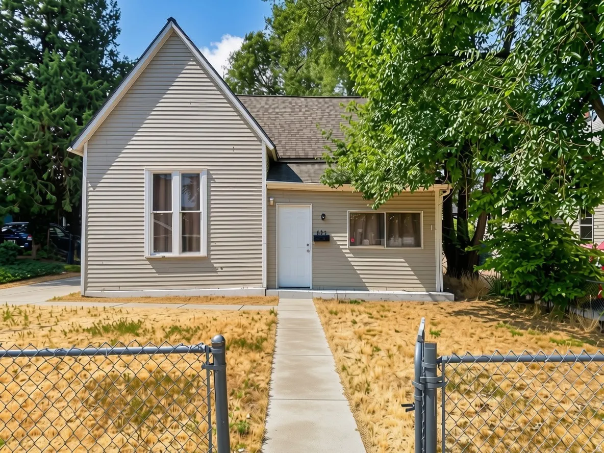 Gable roofline with horizontal siding, front entry door with a rectangular window, and a concrete pathway