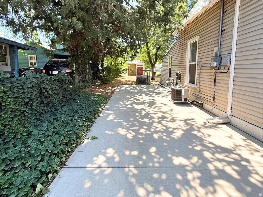 Side-yard driveway. Large shed in the backyard.