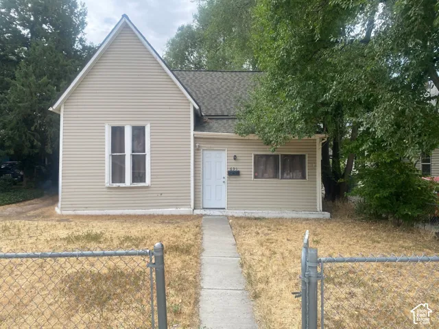 Single-story exterior featuring light-colored horizontal siding, asphalt shingle roofing, and a concrete front walkway