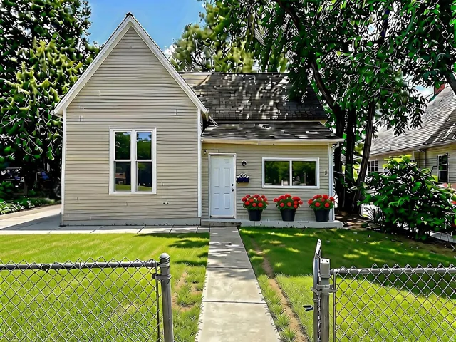 Siding exterior with multiple windows, a front entry door, and a concrete walkway
