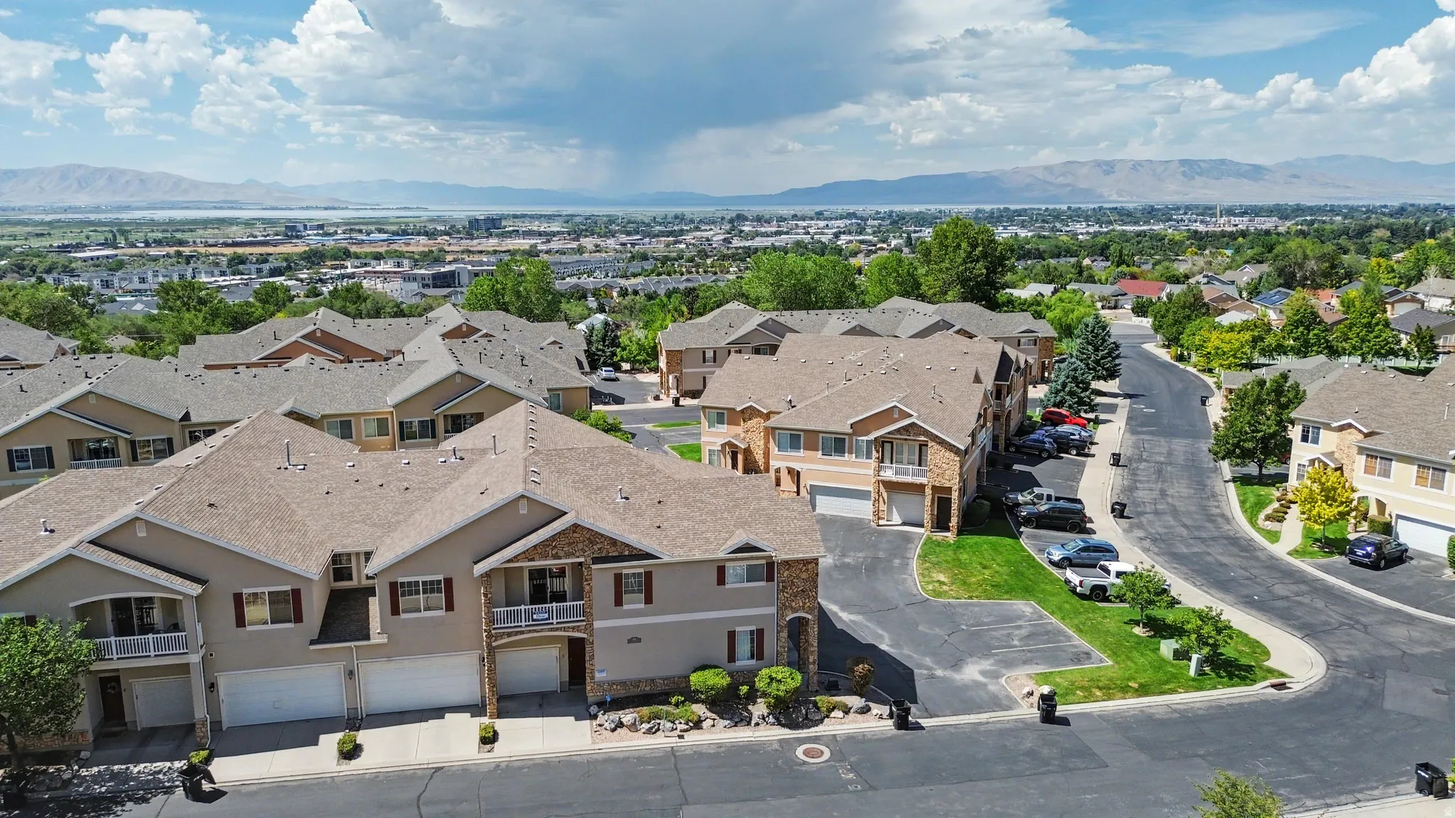 Residential community featuring multi-story townhomes with attached garages and stone accents