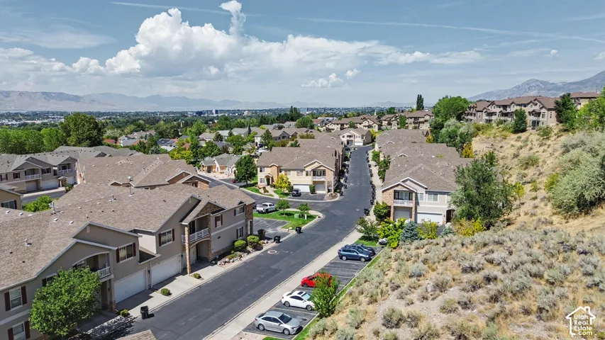 Townhome community with mountain scenery, mature landscaping, and an asphalt street