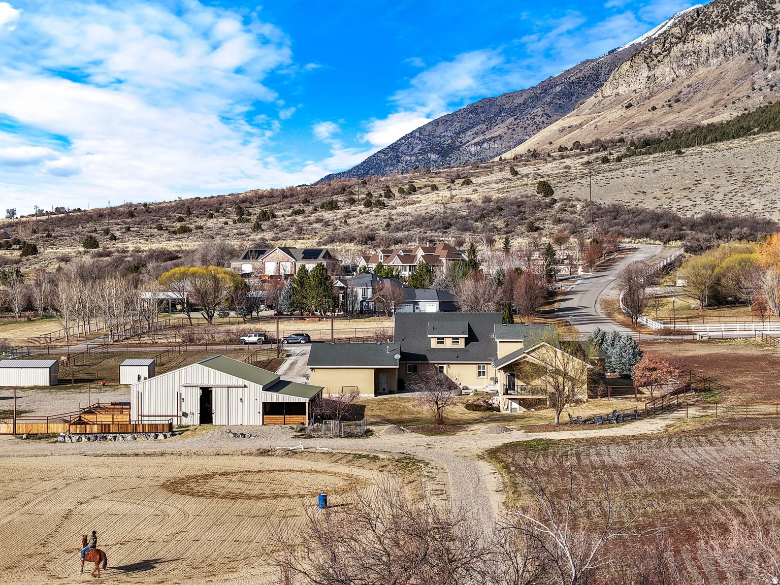Expansive property featuring a large barn, a riding arena, and an accompanying residence with a multi-level design