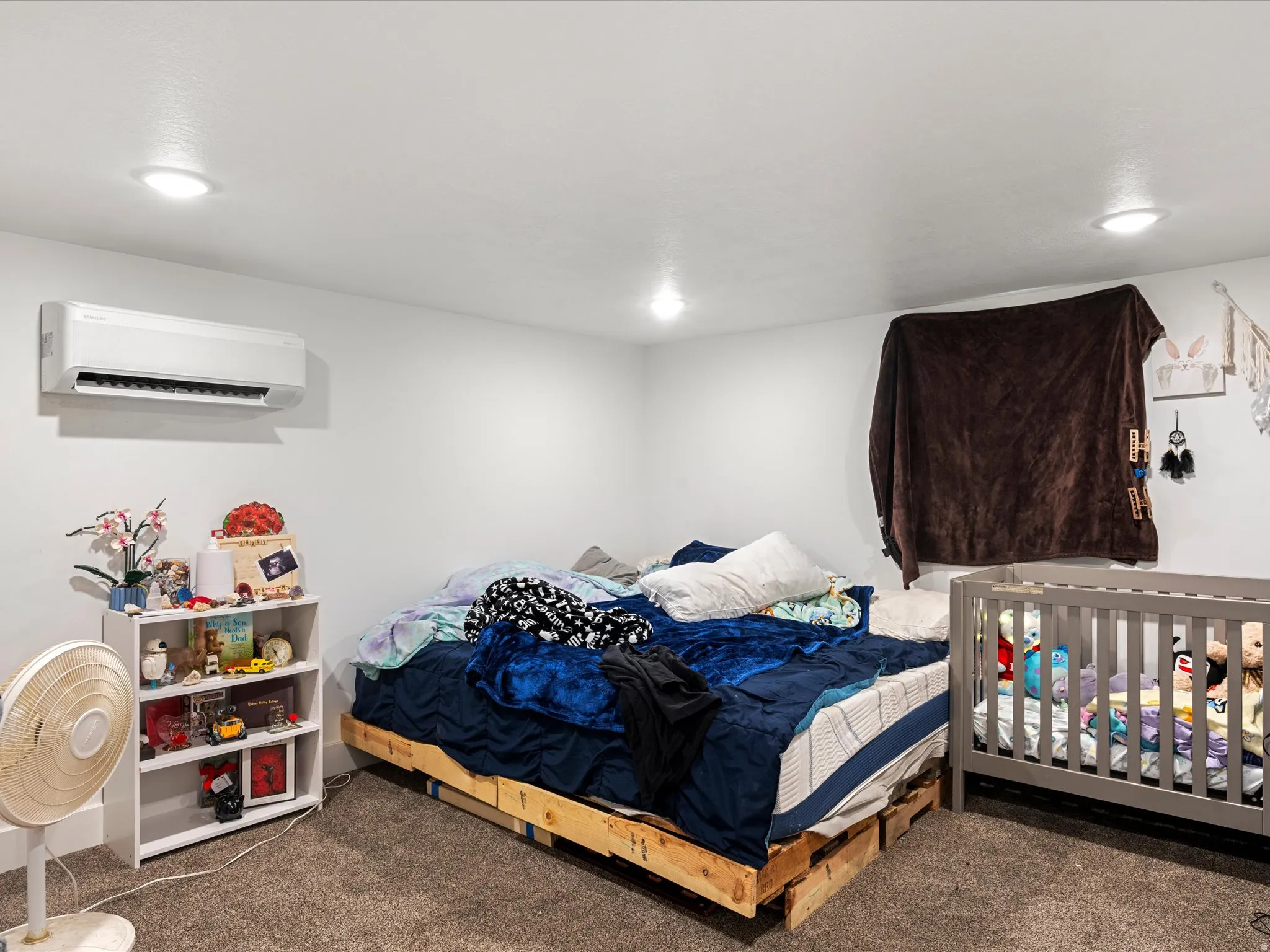 Recessed ceiling lighting, wall-mounted air conditioning unit, and textured carpeting