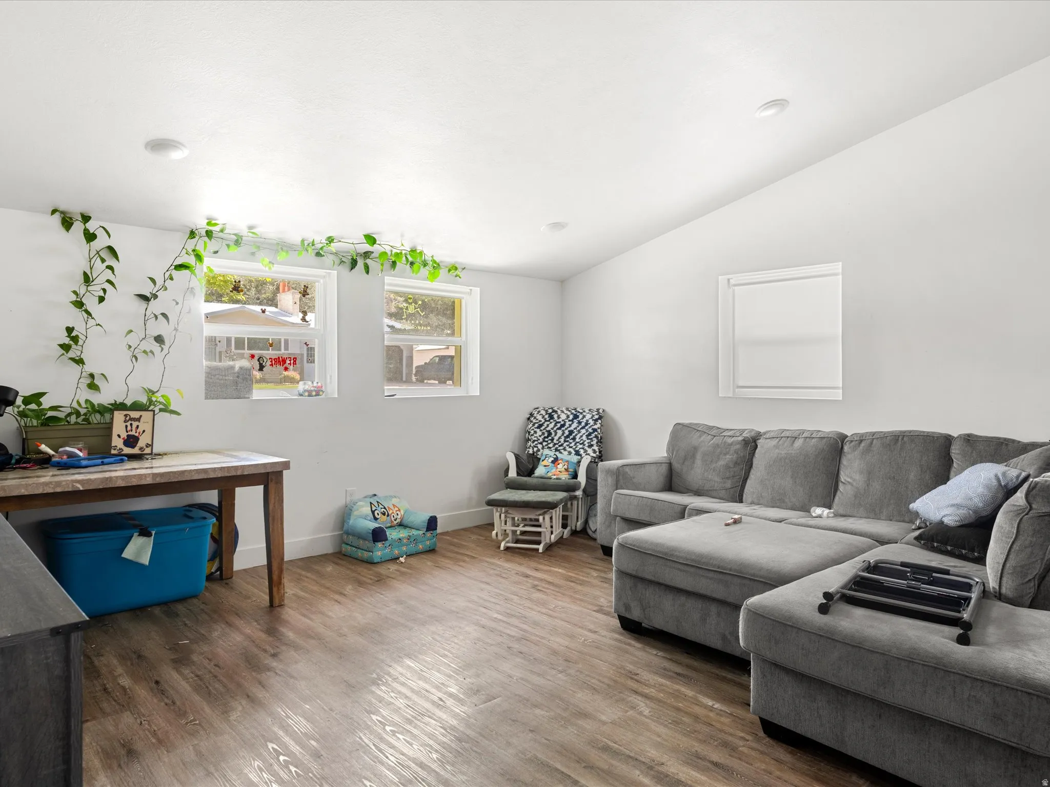 Recessed ceiling lighting, wood-finish flooring, white walls, and multiple windows