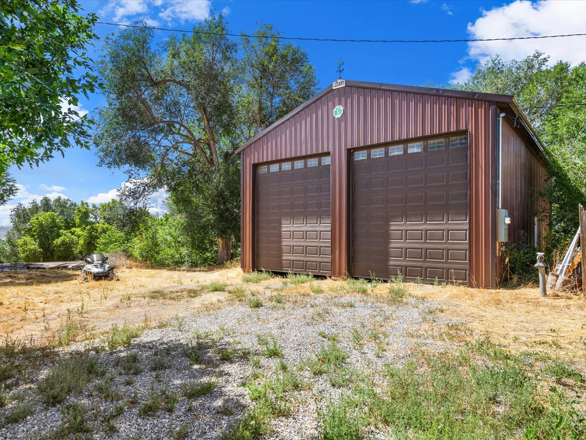 Two-bay metal structure featuring brown paneling and matching garage doors