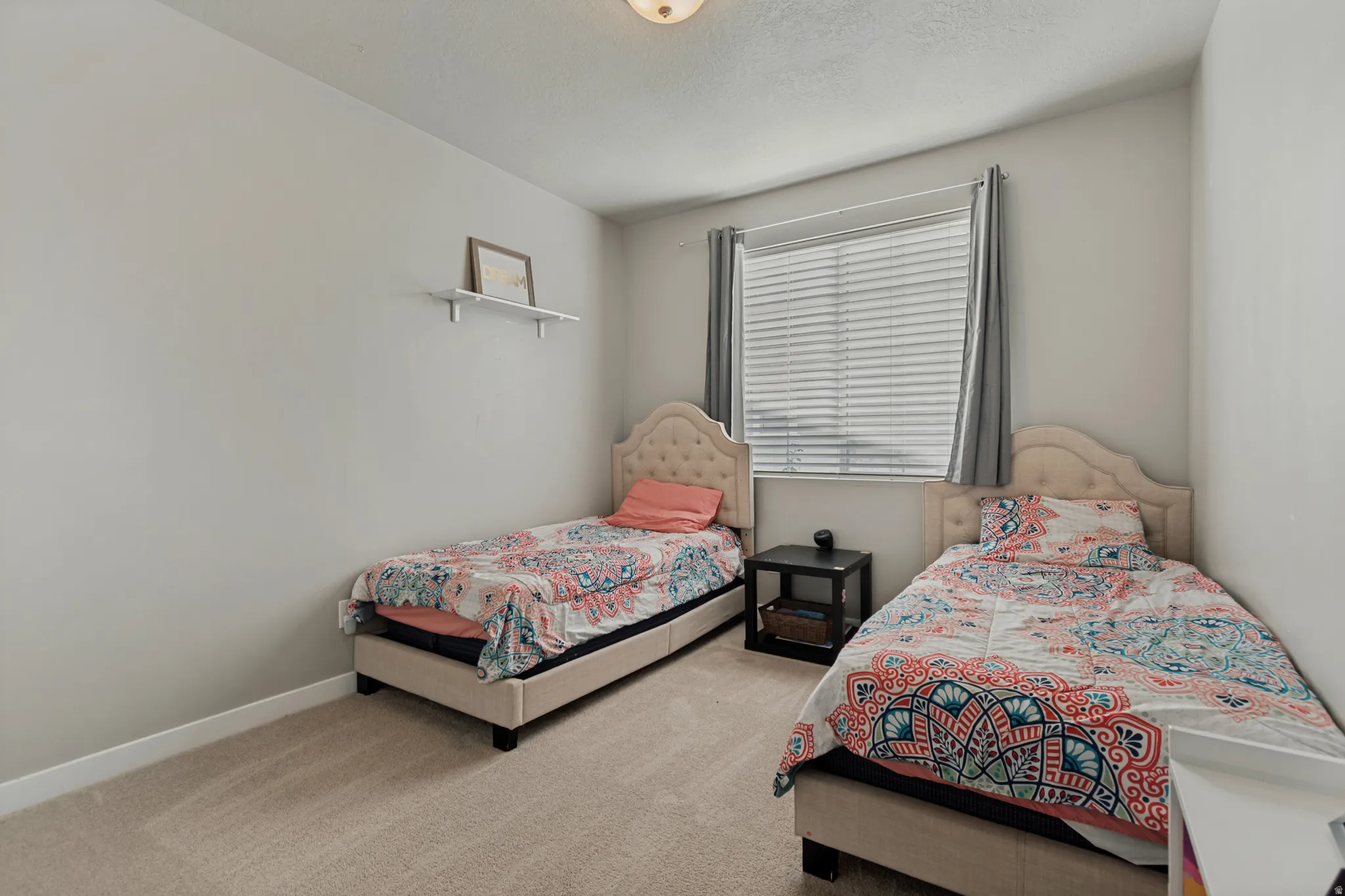 Soft neutral wall tones, carpet flooring, a window with blinds, and recessed lighting