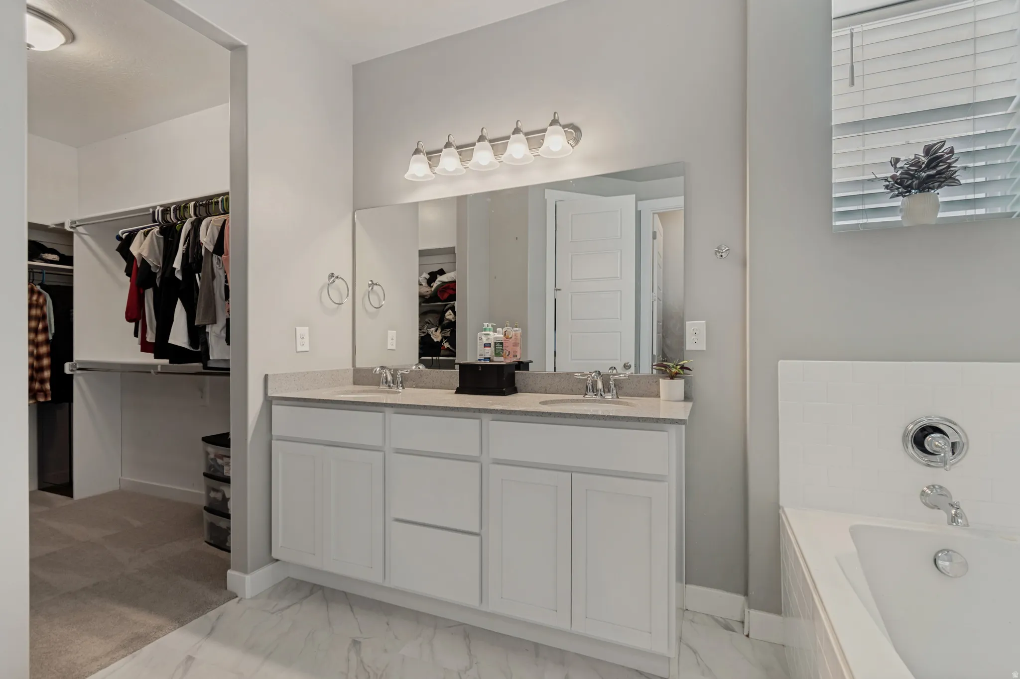 Dual vanity with white cabinetry and light-colored countertop