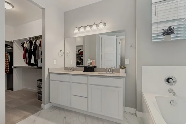Dual vanity with white cabinetry and light-colored countertop