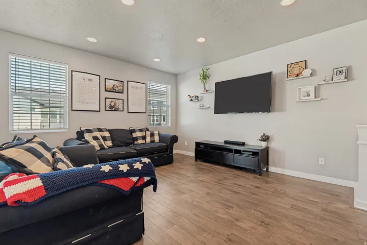Recessed lighting, light gray wall paint, wood-finish flooring, and multiple windows with blinds