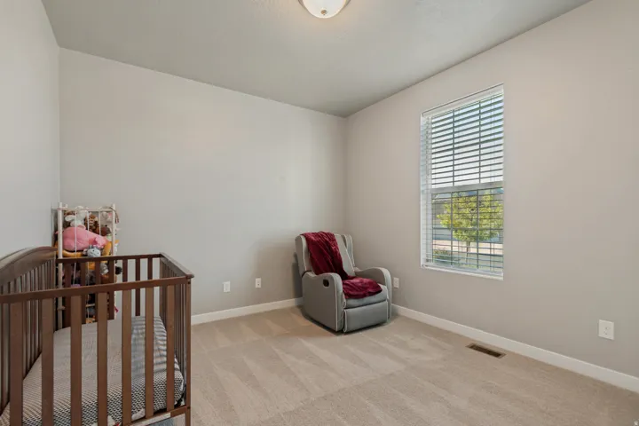 Neutral wall paint, carpet flooring, a window with horizontal blinds, and a flush mount ceiling light