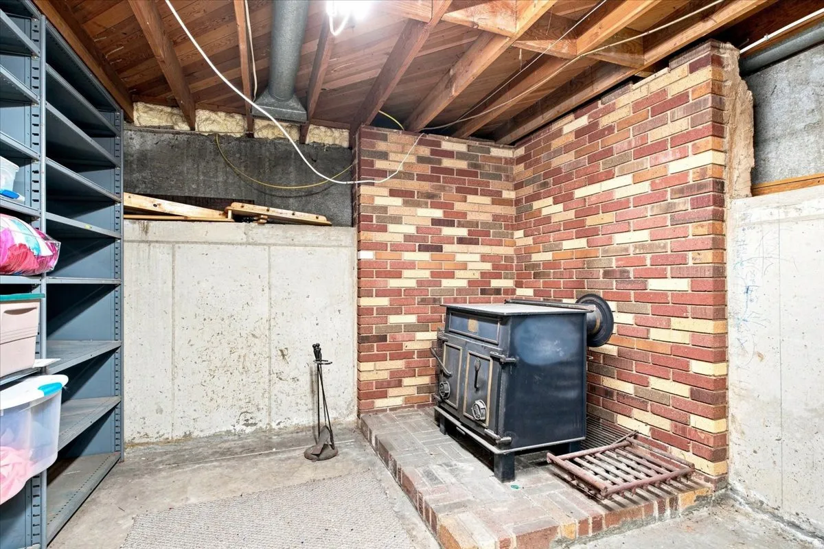 Brick accent wall with a built-in wood-burning stove and concrete flooring