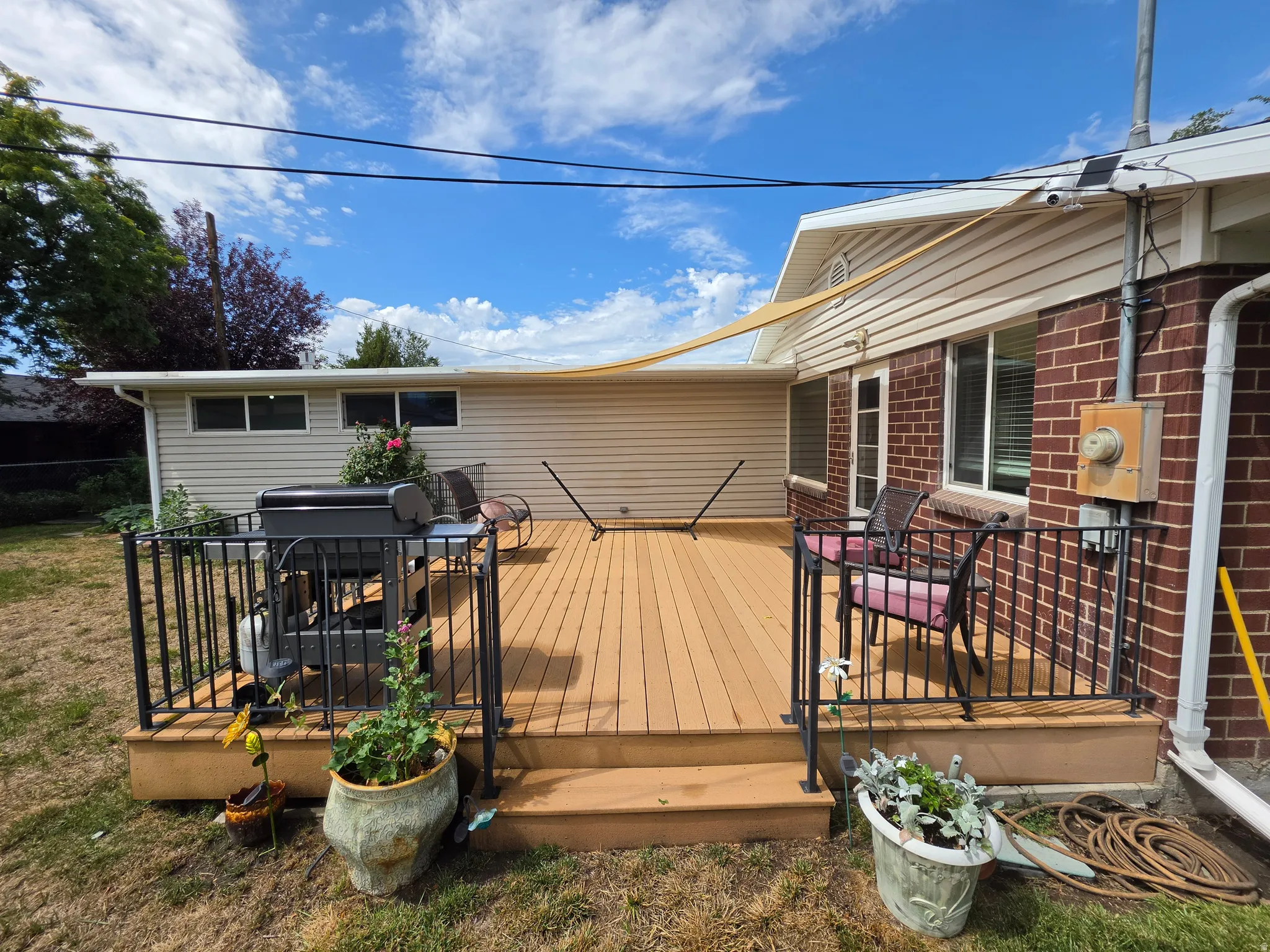 Expansive outdoor deck with wood-finish planks and black metal railings