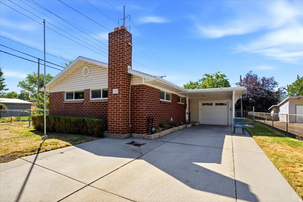 Brick exterior with light-colored siding, attached carport, and a concrete driveway
