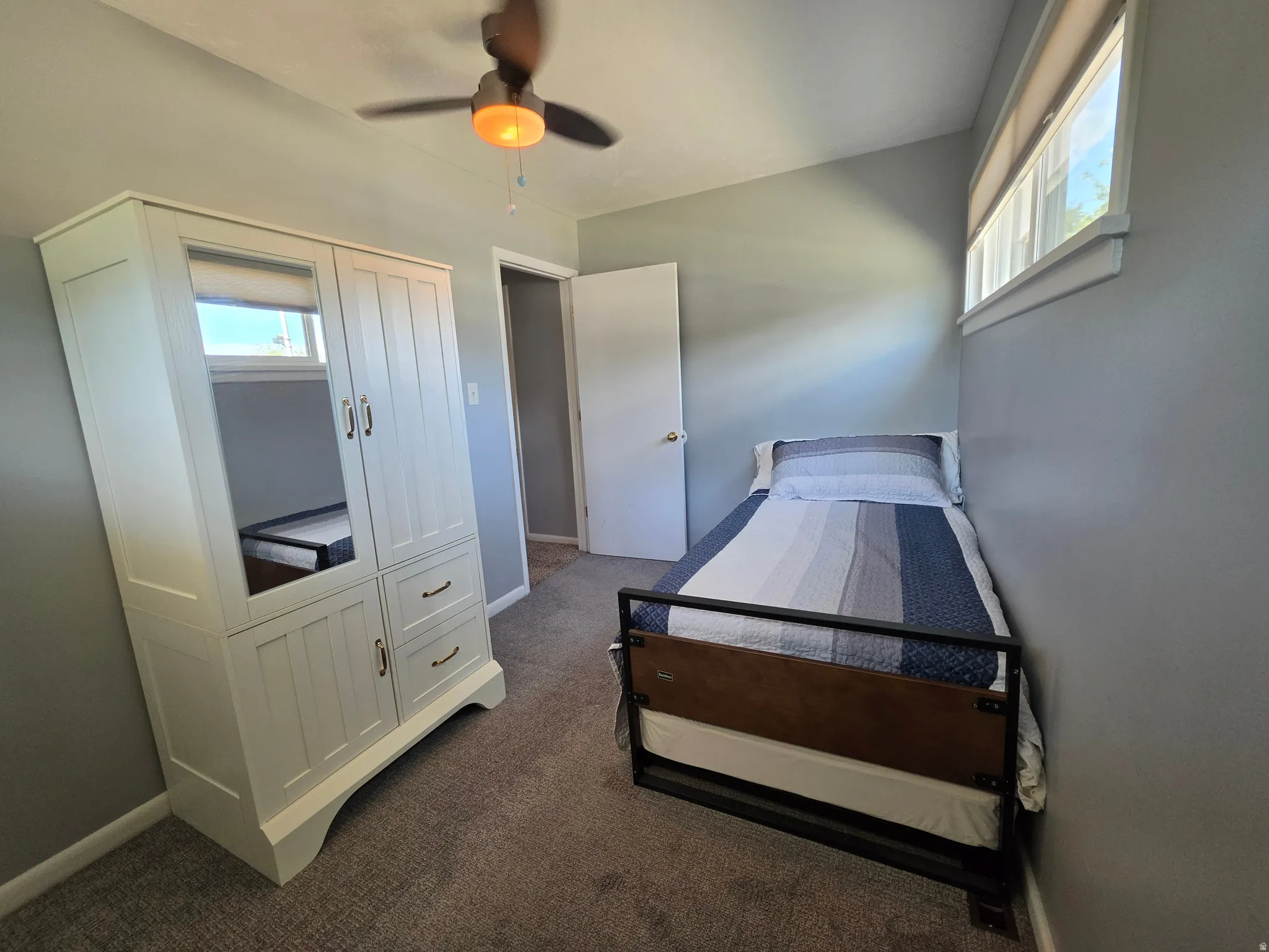 Recessed lighting, wood-finish ceiling fan with light kit, and a single window with roller shade