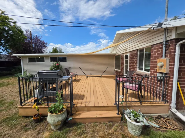 Expansive outdoor deck with wood-finish planks and black metal railings