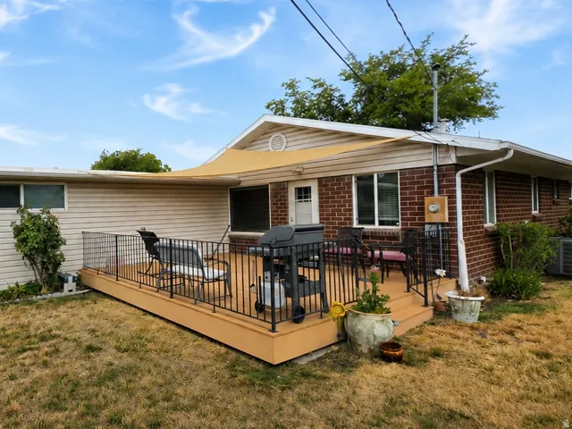 Expansive outdoor deck with a shade sail, metal railing, and direct exterior access