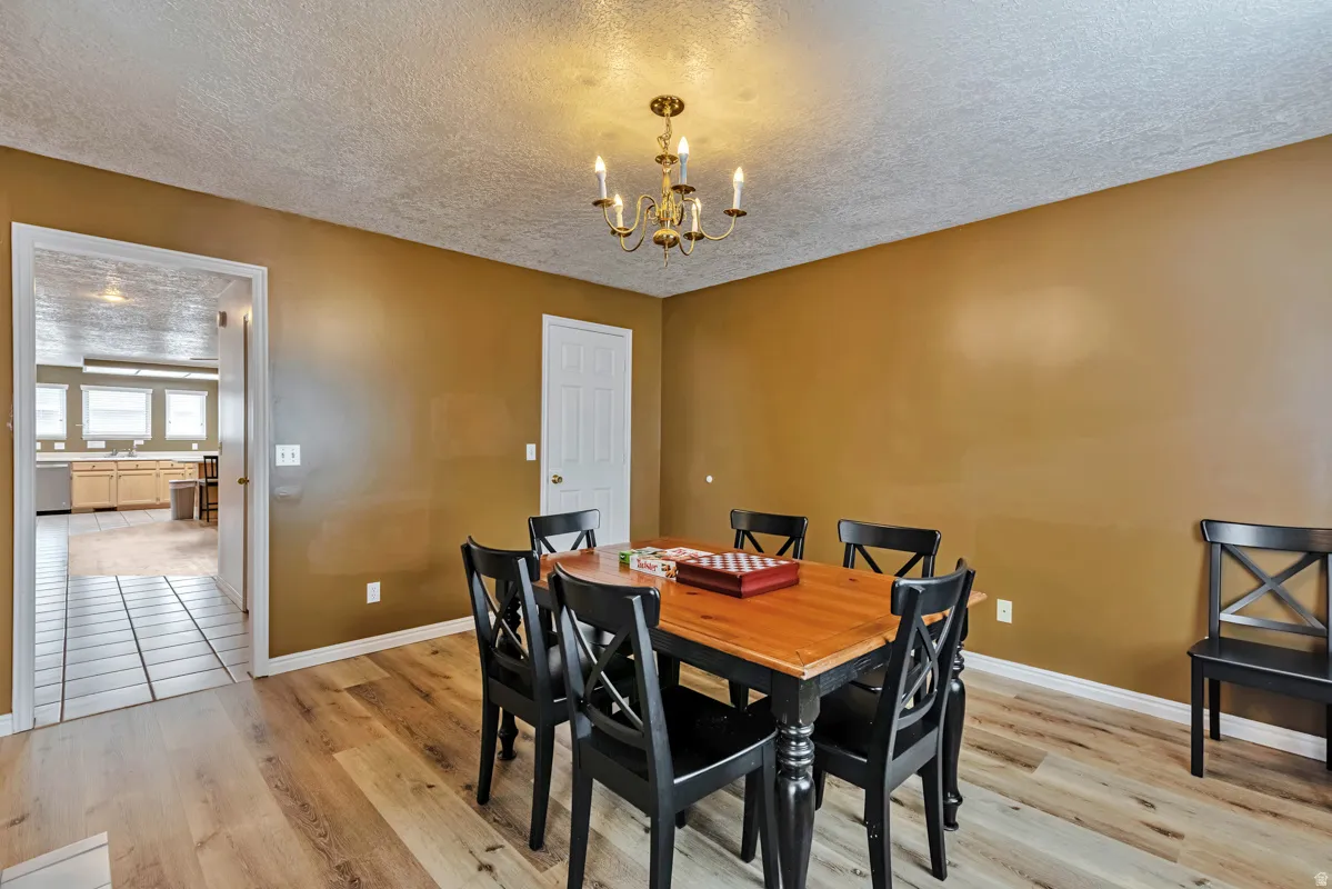 Wood-finish flooring, warm-toned wall paint, and a brass-tone chandelier