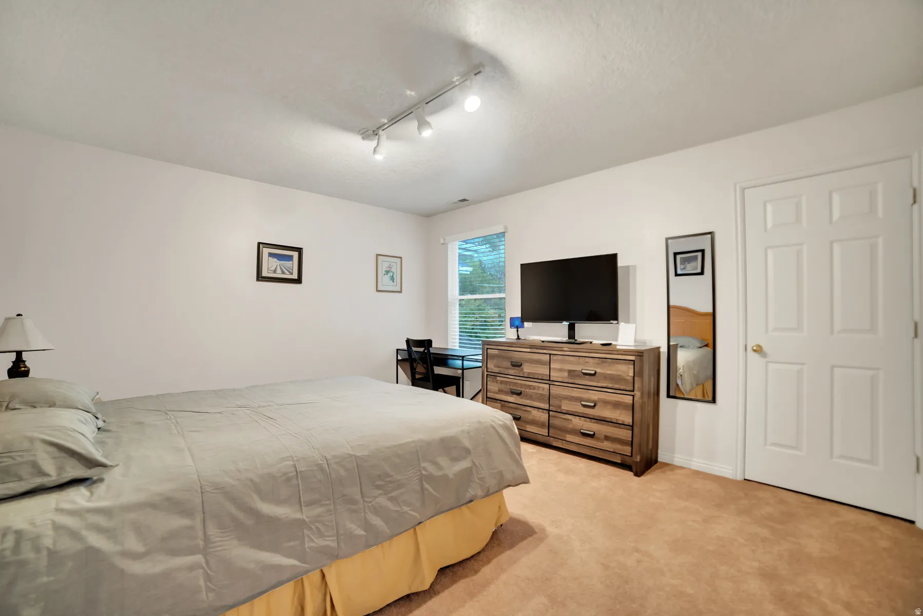Recessed lighting fixtures, window with blinds, panel door, and neutral-toned wall paint