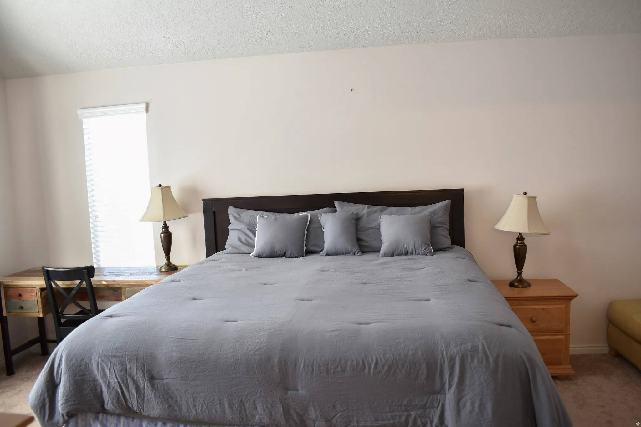 Recessed window with blinds, textured ceiling, and neutral wall paint