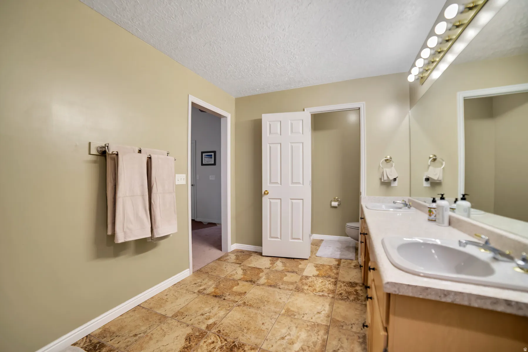 Dual vanity with integrated sinks, expansive mirror, and overhead lighting