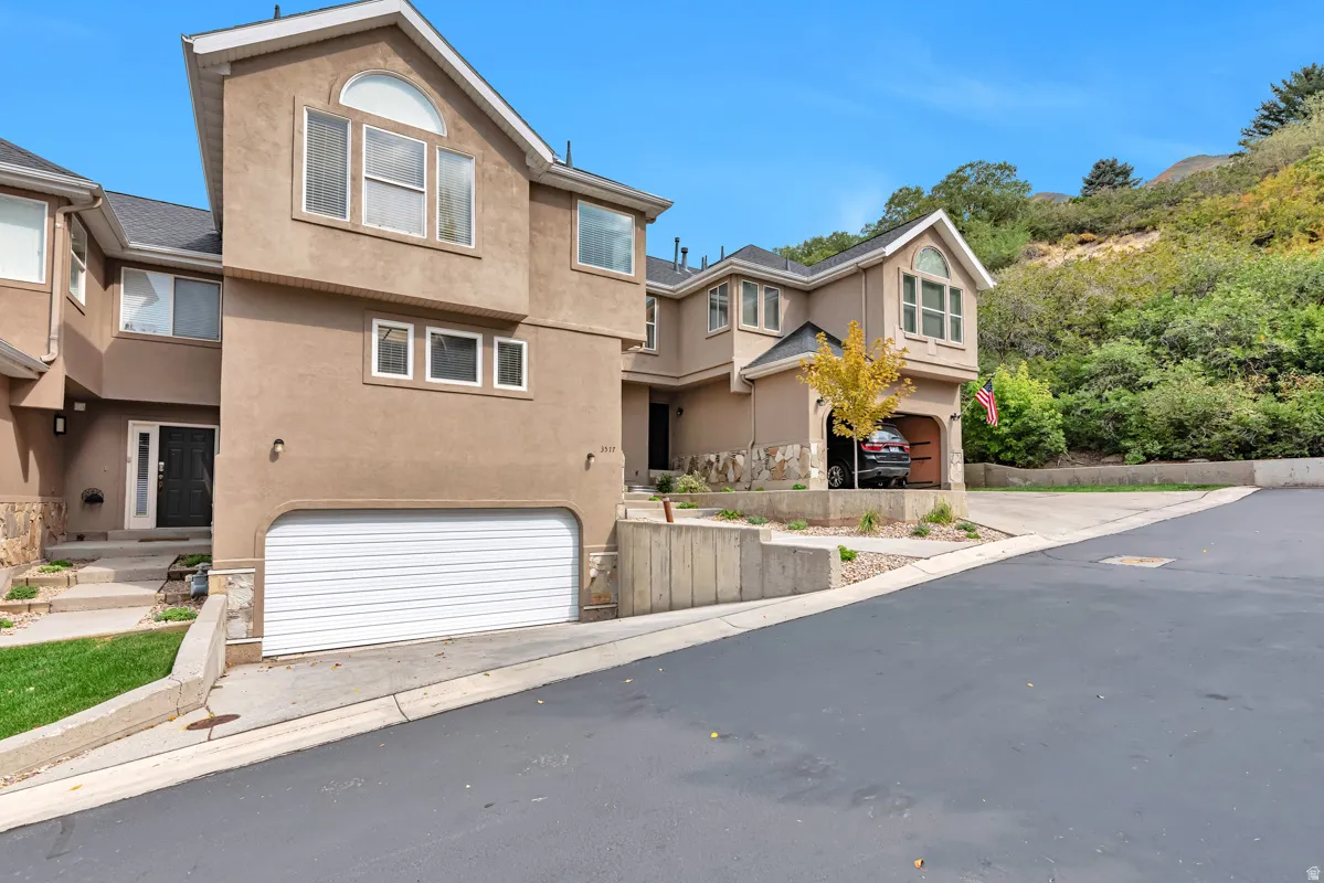 Stucco exterior with stone accents, multiple garage spaces, and gabled rooflines