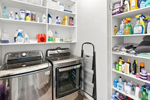 Integrated laundry appliances, ample open shelving, and bright white walls