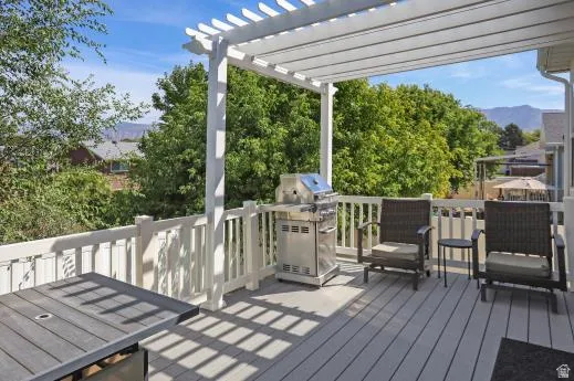 Expansive outdoor deck with a white slatted pergola, composite decking, and painted white railings