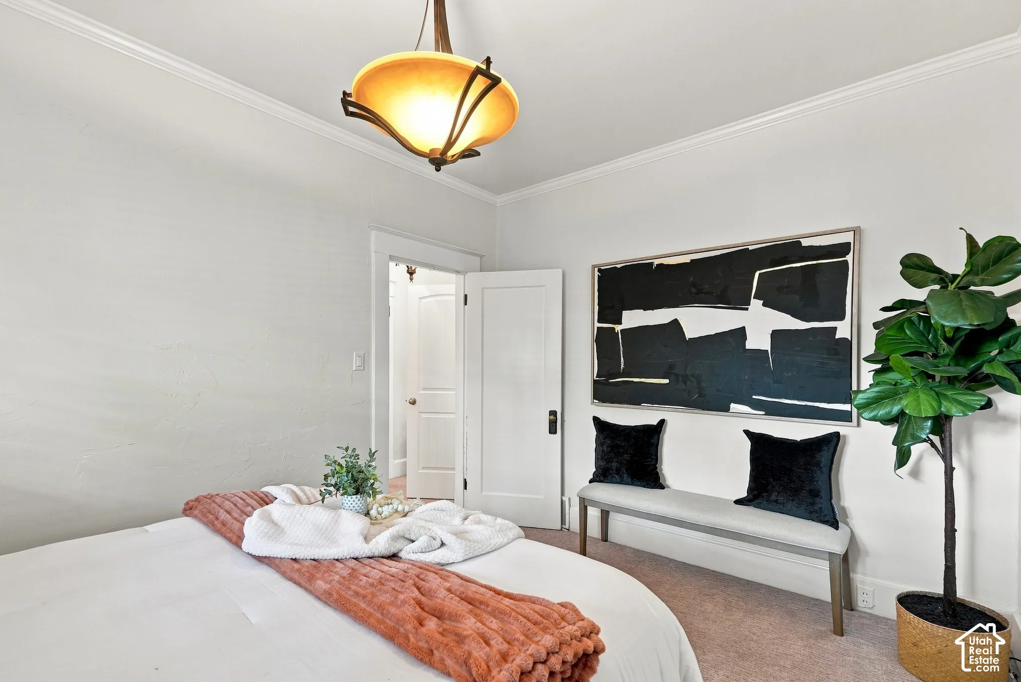 Bright bedroom with soft-close closet doors, recessed ceiling lighting with brass pendant fixture, and potted greenery