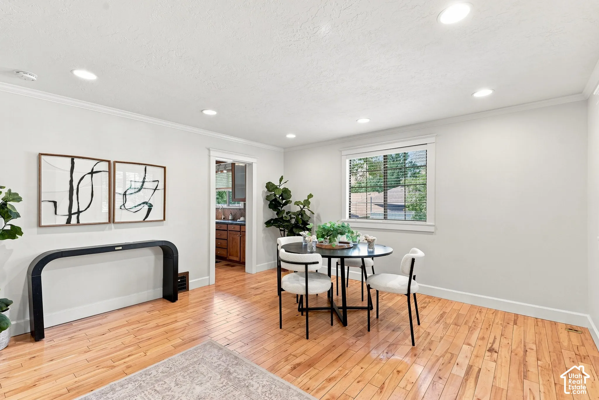 Recessed lighting, crown molding, wood-finish flooring, white trim, and window with blinds