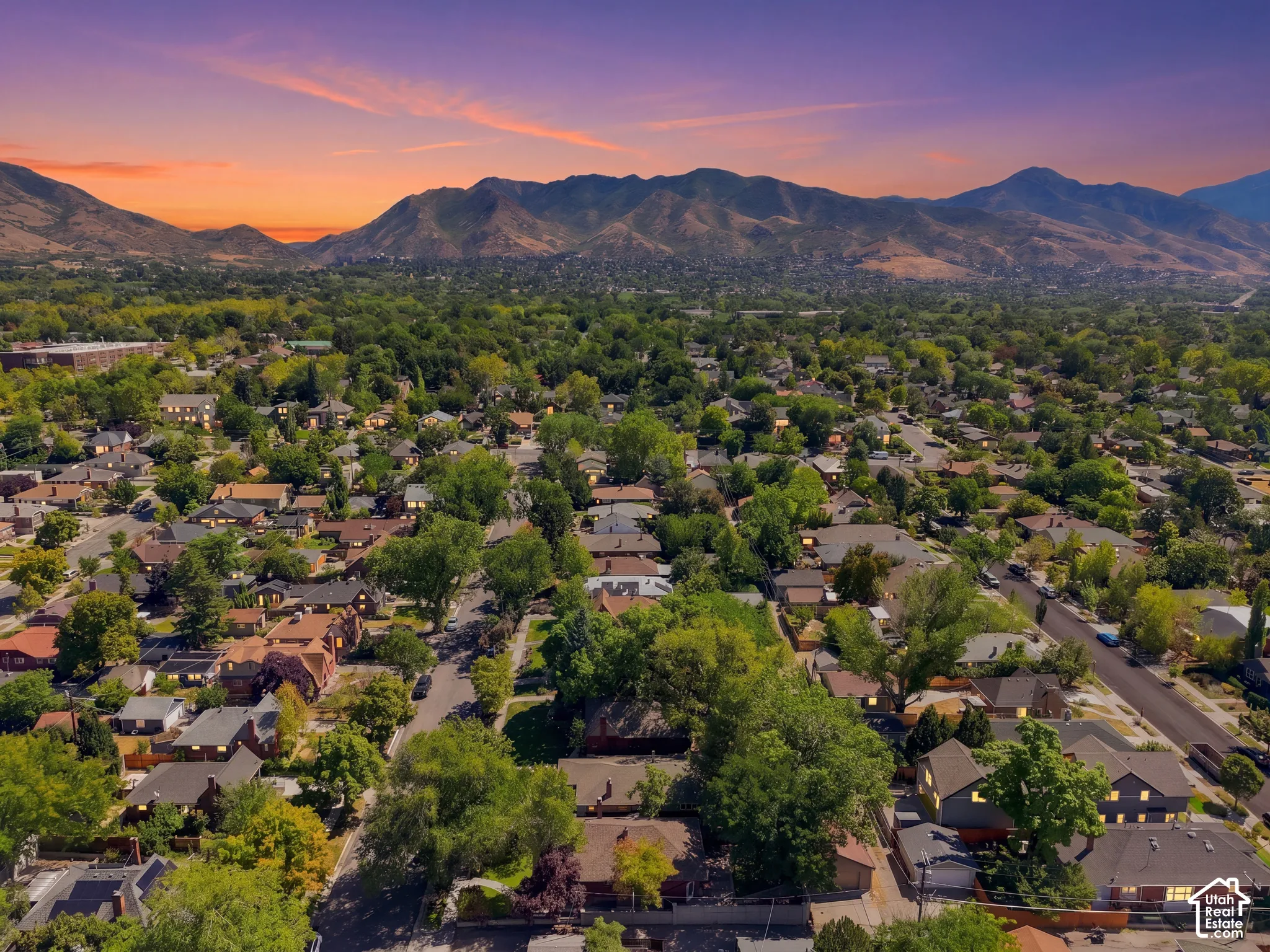 Expansive residential area with mature trees and mountain scenery