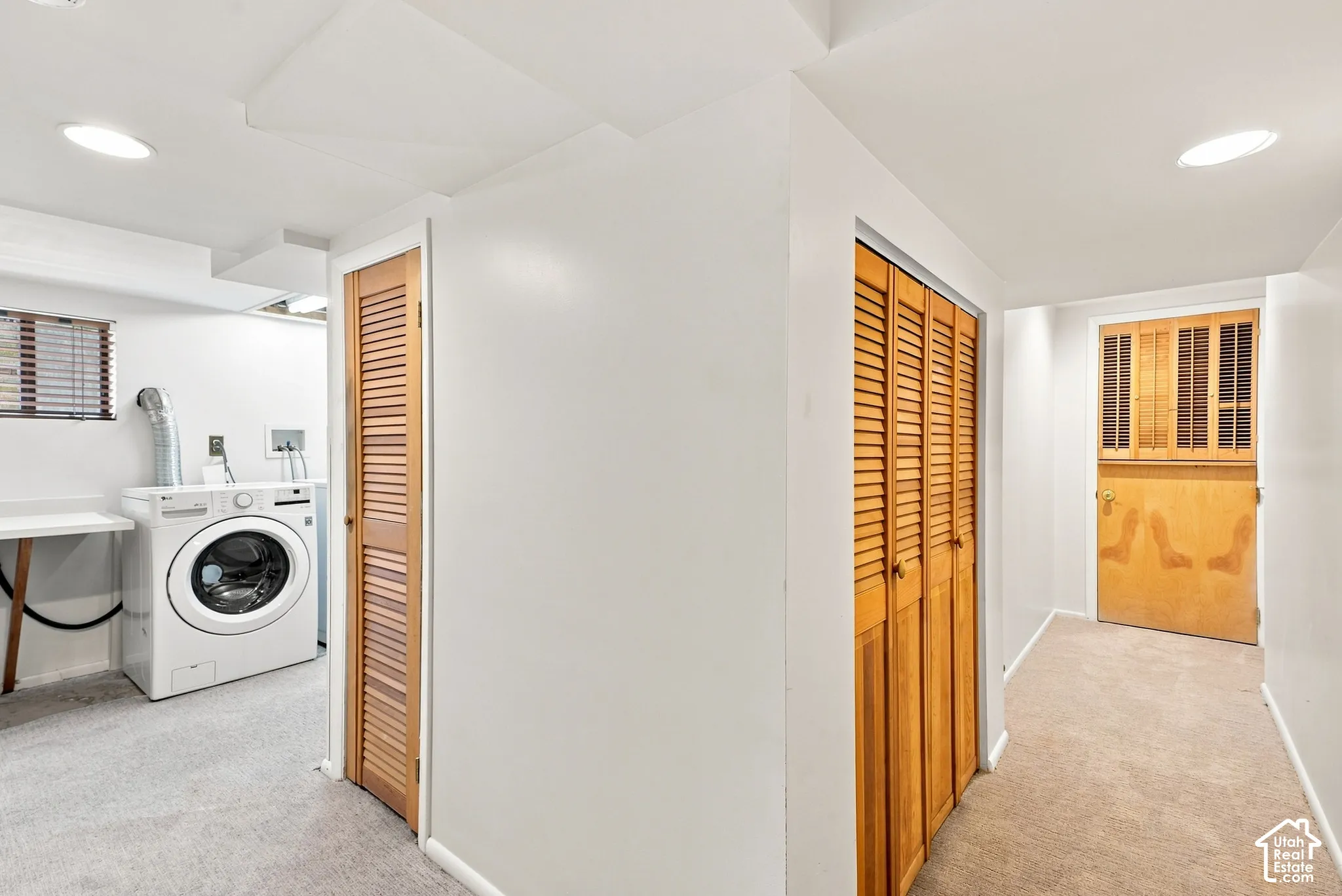 Laundry area with recessed lighting, light-toned carpeting, and louvered wood doors