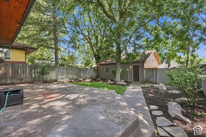 Mature shade trees and expansive hardscaped patio create an inviting outdoor retreat
