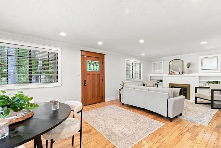 Hardwood flooring throughout, recessed lighting, and a wood-frame front door with decorative glass