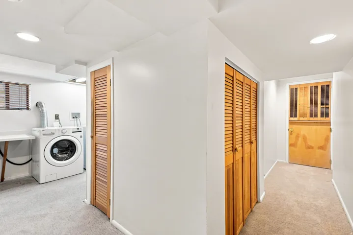 Laundry area with recessed lighting, light-toned carpeting, and louvered wood doors