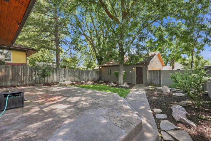 Mature shade trees and expansive hardscaped patio create an inviting outdoor retreat