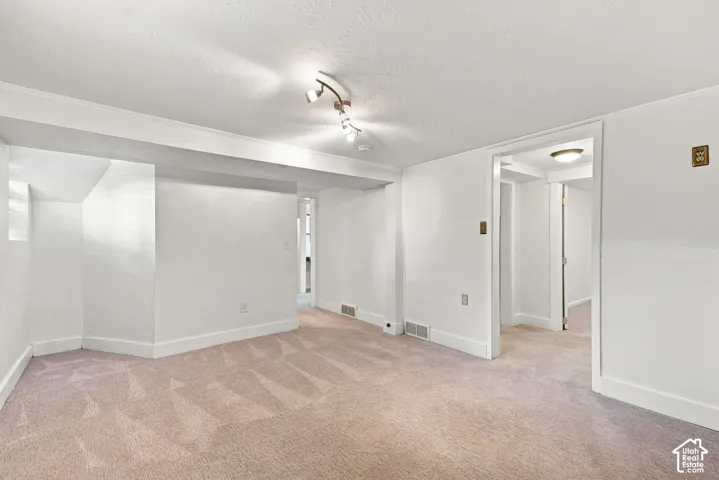 Spacious open floor plan with neutral carpeting, white walls, and recessed ceiling lighting