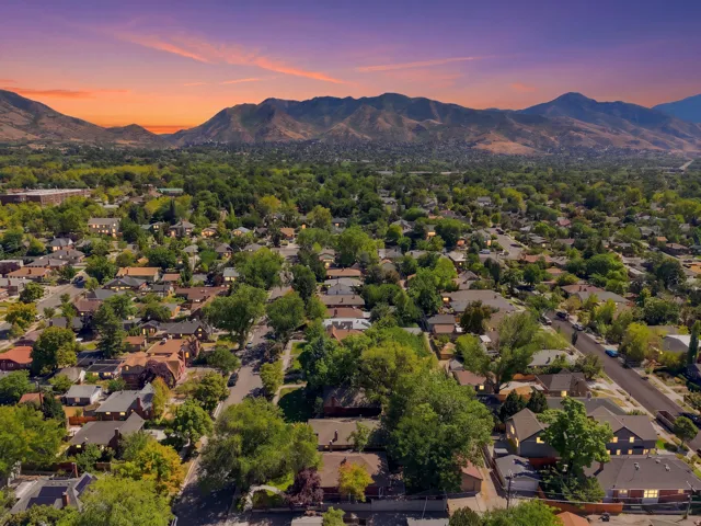 Expansive residential area with mature trees and mountain scenery