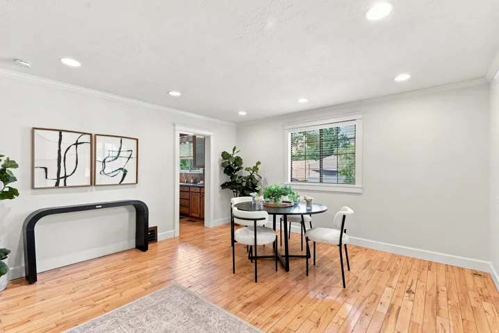 Recessed lighting, crown molding, wood-finish flooring, white trim, and window with blinds