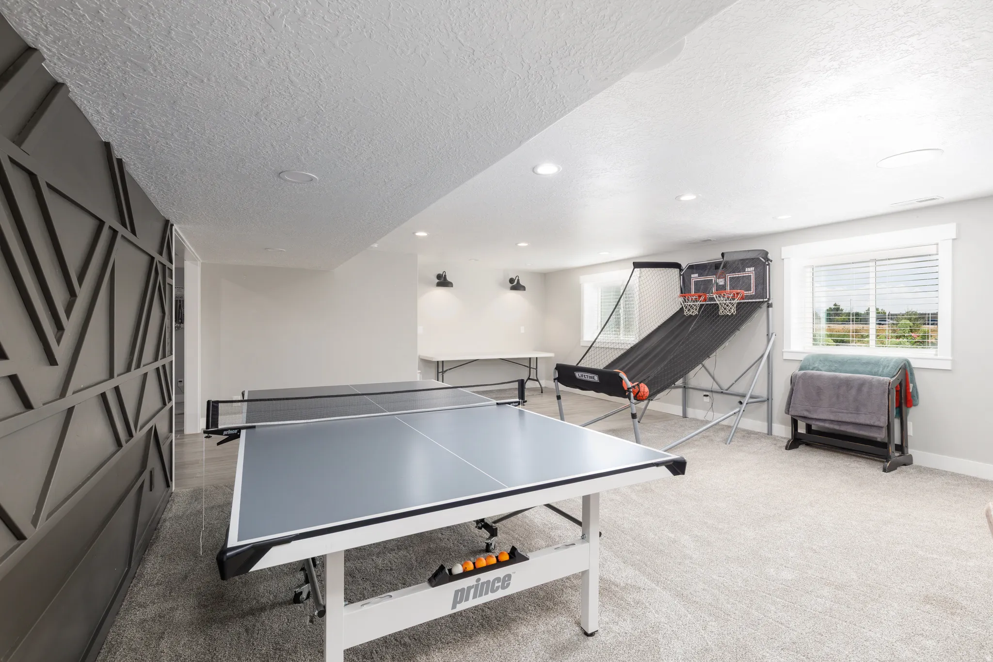Spacious open room with recessed lighting, carpet flooring, and a decorative accent wall