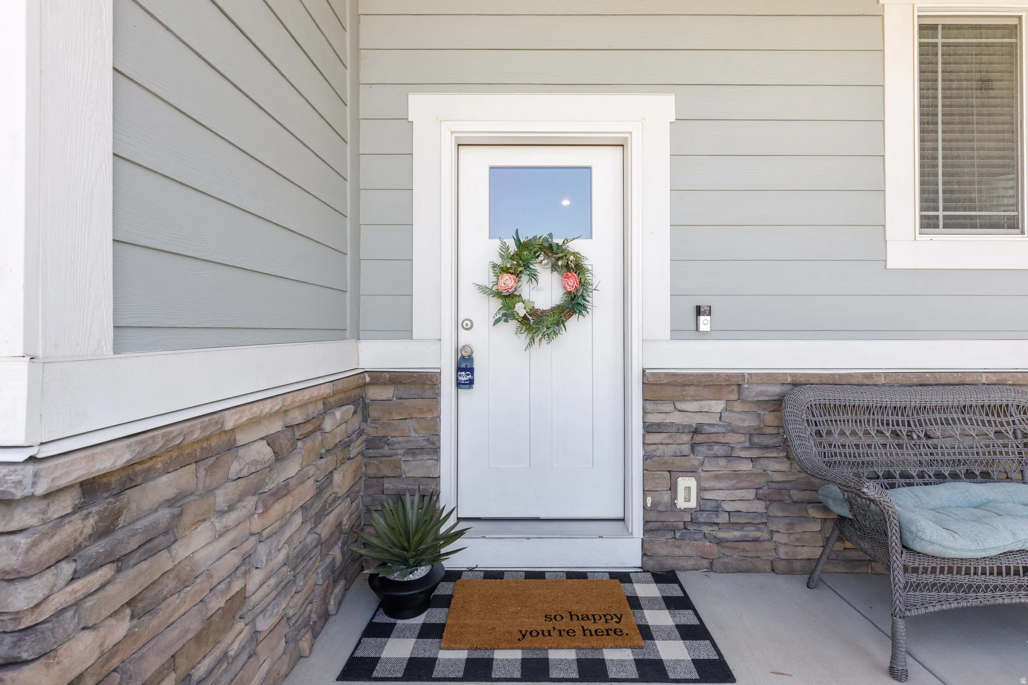 Front entry with light blue horizontal siding, stone veneer accents, and white trim