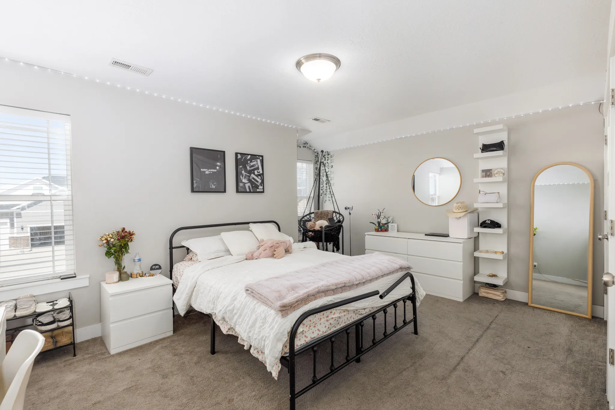 Spacious room with light neutral walls, a large window, and soft carpet flooring