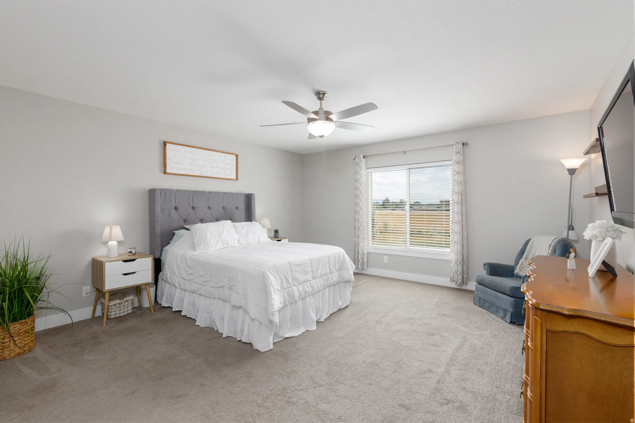 Neutral toned walls with carpet flooring, a ceiling fan with integrated lighting, and a window with blinds