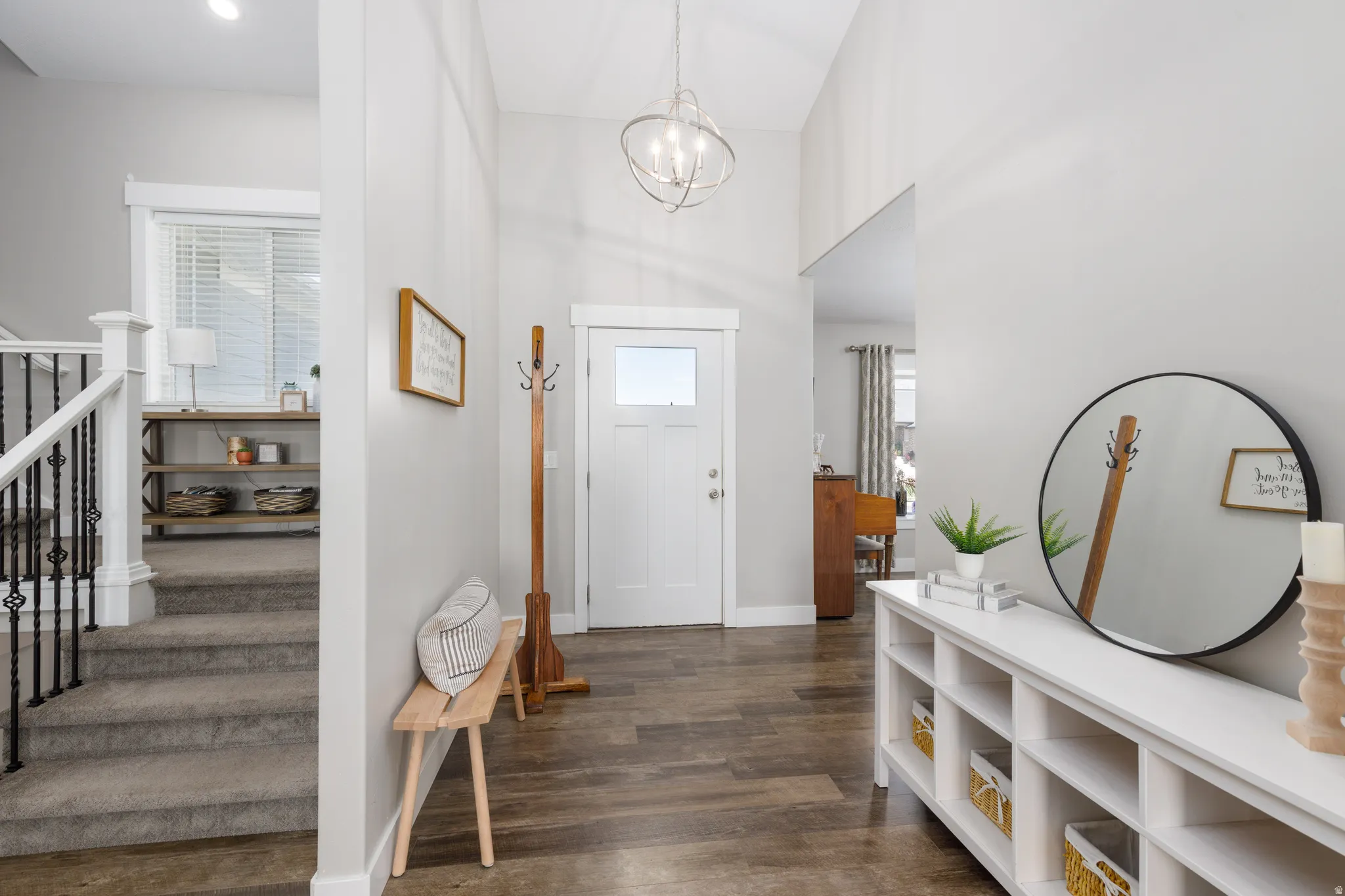 Foyer with wood-finish flooring, vaulted ceiling, and a prominent front entry door with glass paneling