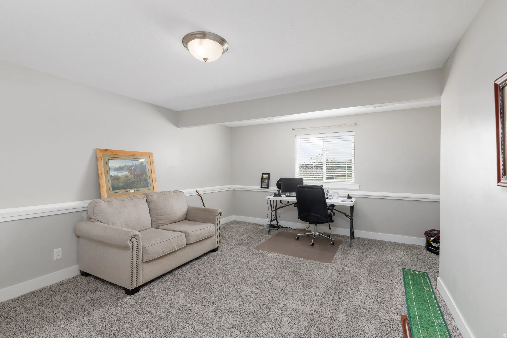 Carpeted floor, neutral wall paint, window with blinds, ceiling-mounted light fixture, and white trim