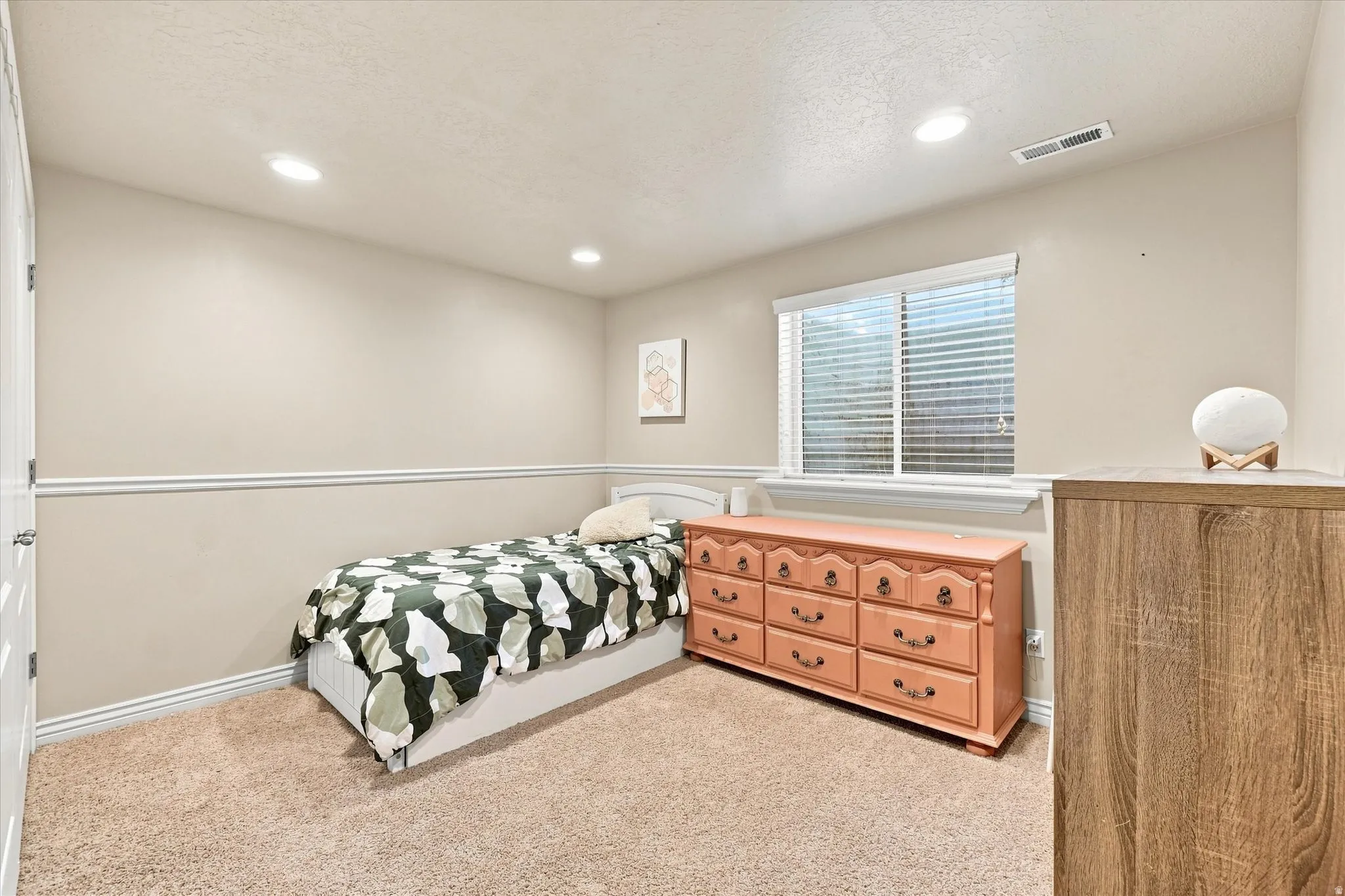 Recessed lighting, window with blinds, neutral wall paint, white trim, and light-toned carpet