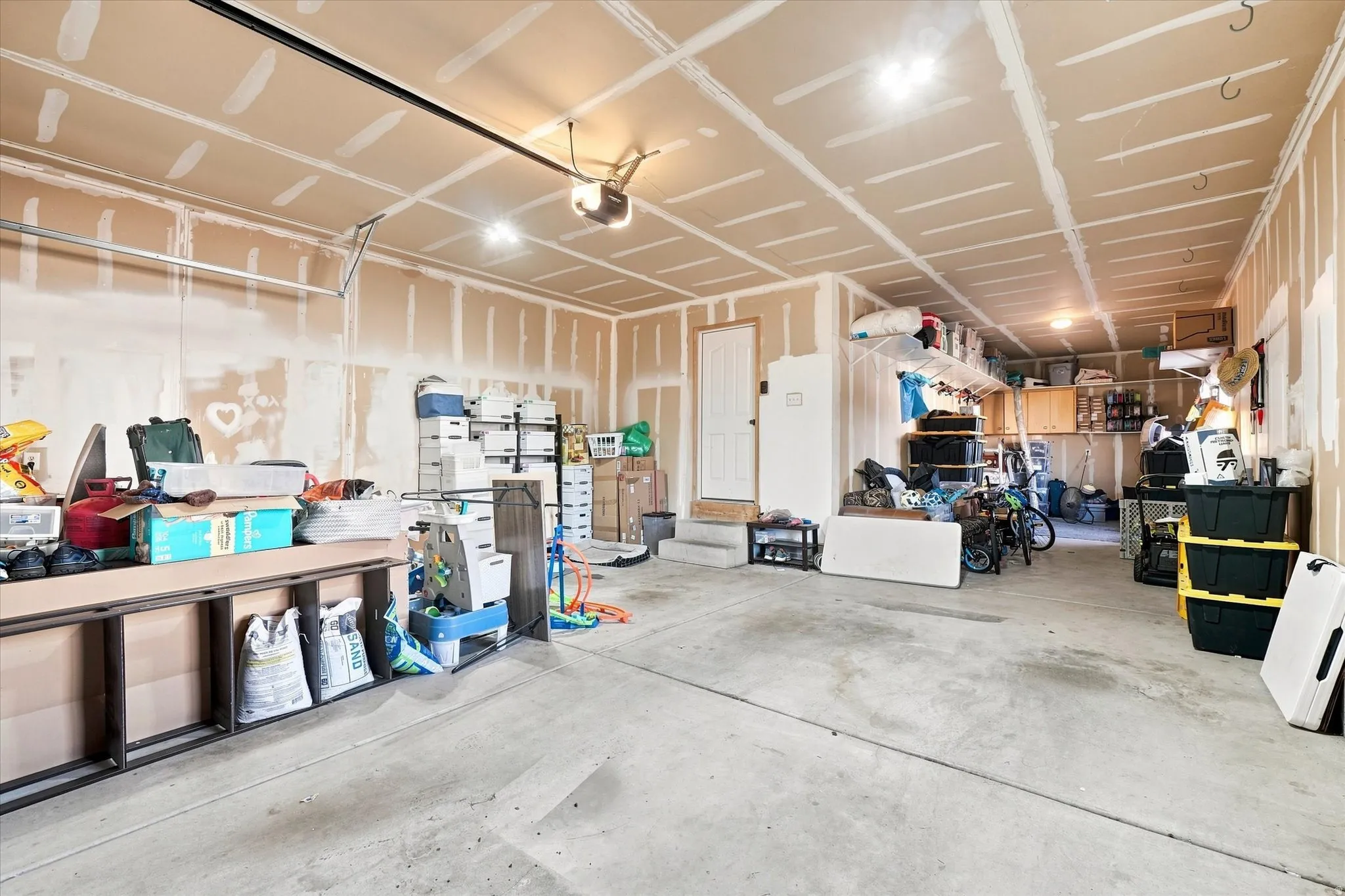 Attached garage featuring a concrete floor and exposed drywall
