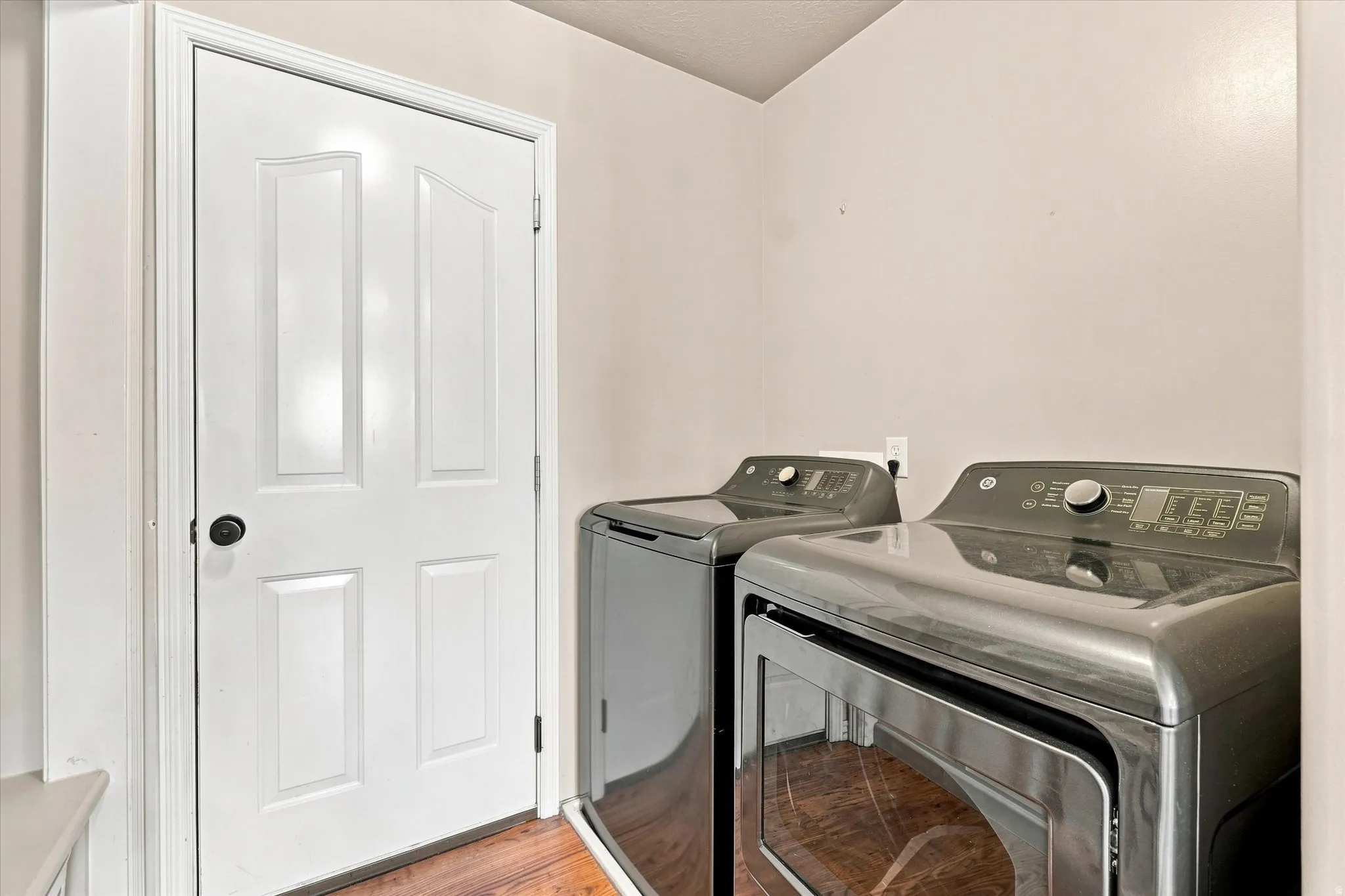 Laundry area with wood-finish flooring