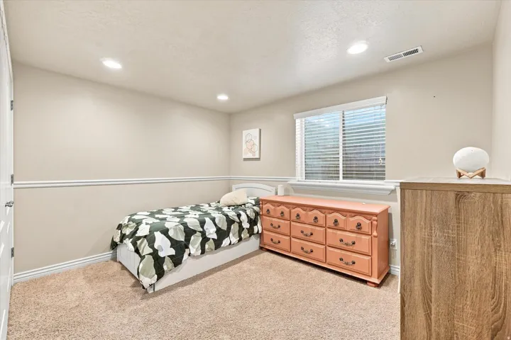 Recessed lighting, window with blinds, neutral wall paint, white trim, and light-toned carpet