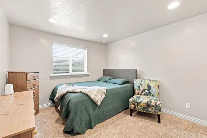 Recessed lighting illuminates neutral-toned walls and plush carpeting